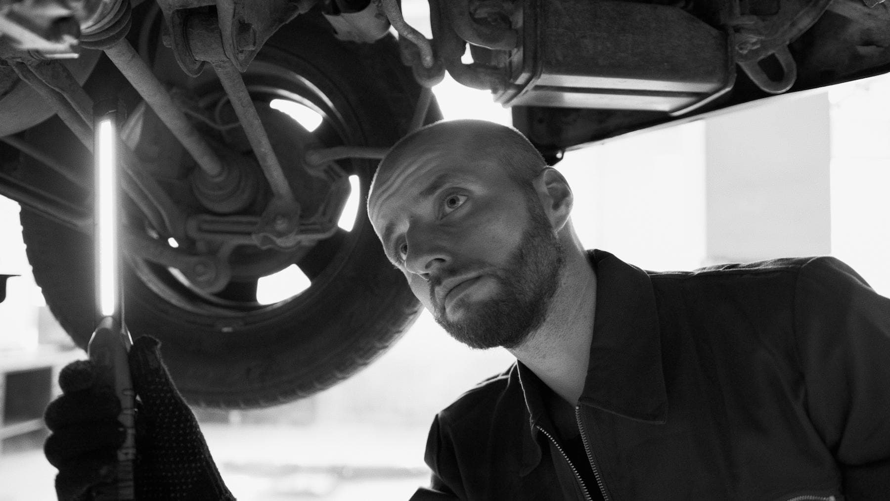 Professional conducting a detailed vehicle undercarriage inspection